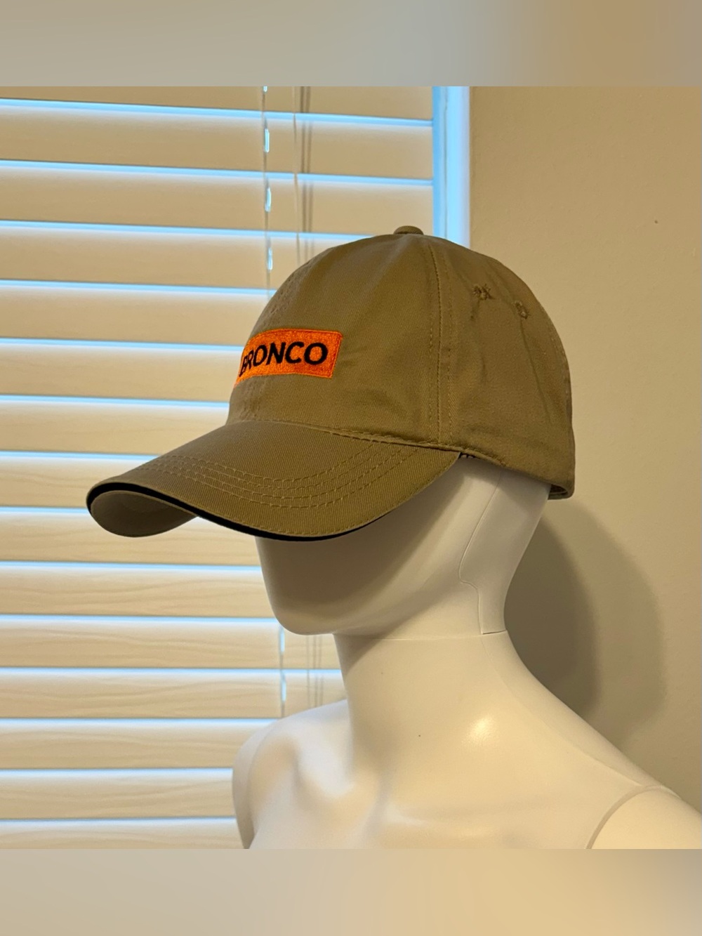 BRONCO – a sand-colored baseball cap featuring a rectangular orange patch with